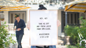 A woman holding a sign promoting Original ChopShops latest loyalty promotion