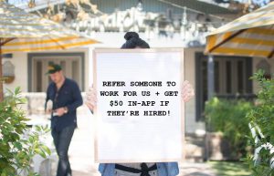 A woman holding a sign showing Original ChopShops latest Loyalty Promotion