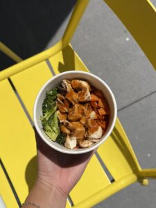 A Kid's Teriyaki Chicken Protein Bowl in front of a yellow patio chair from Original ChopShop